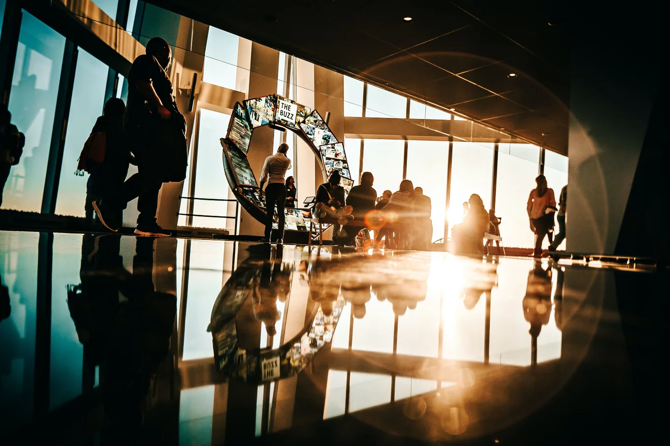Silhouetted people, large display, bright sunlight.